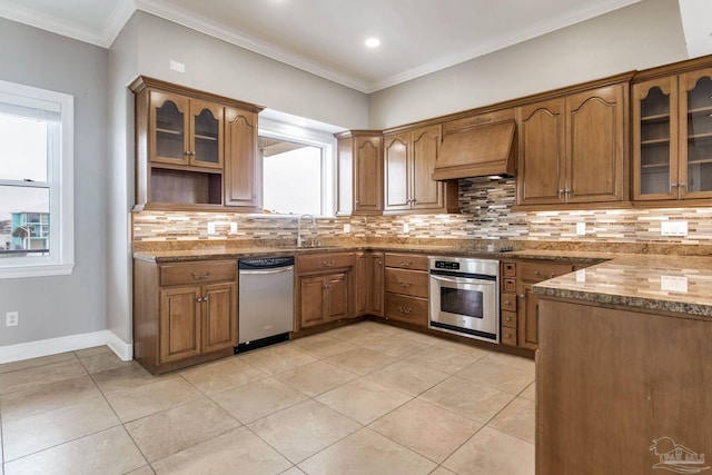 kitchen featuring custom exhaust hood, a wealth of natural light, appliances with stainless steel finishes, and a sink