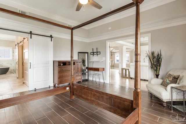 interior space featuring ornamental molding, a ceiling fan, visible vents, and a barn door