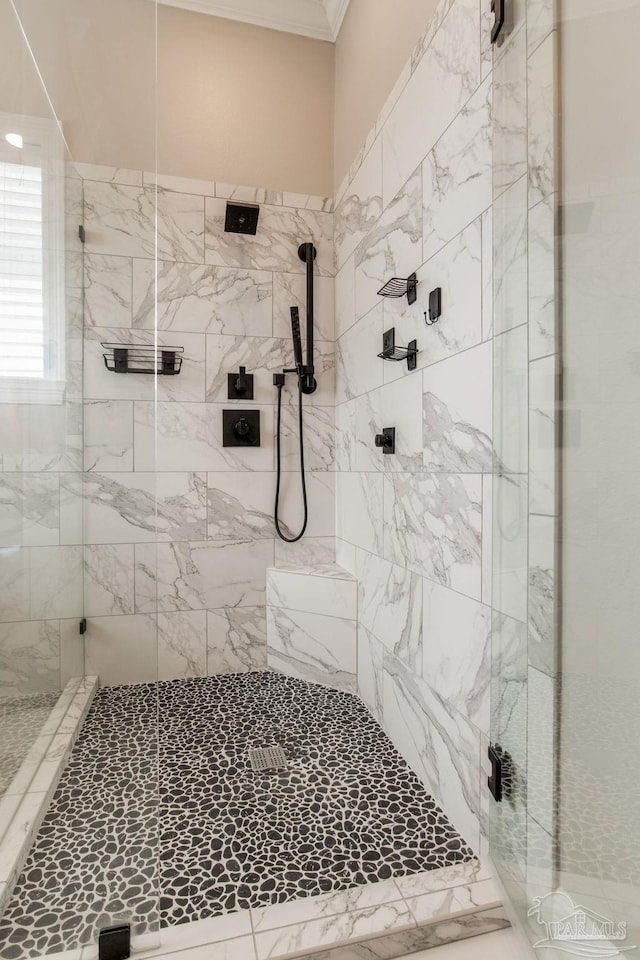 bathroom with ornamental molding and a stall shower