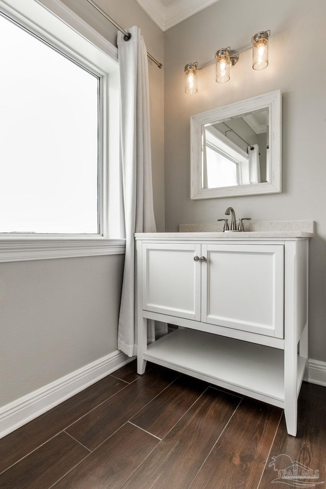 bathroom with vanity, baseboards, and wood finished floors