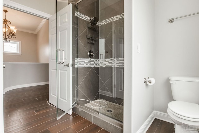 bathroom featuring a shower stall, wood finished floors, baseboards, and ornamental molding
