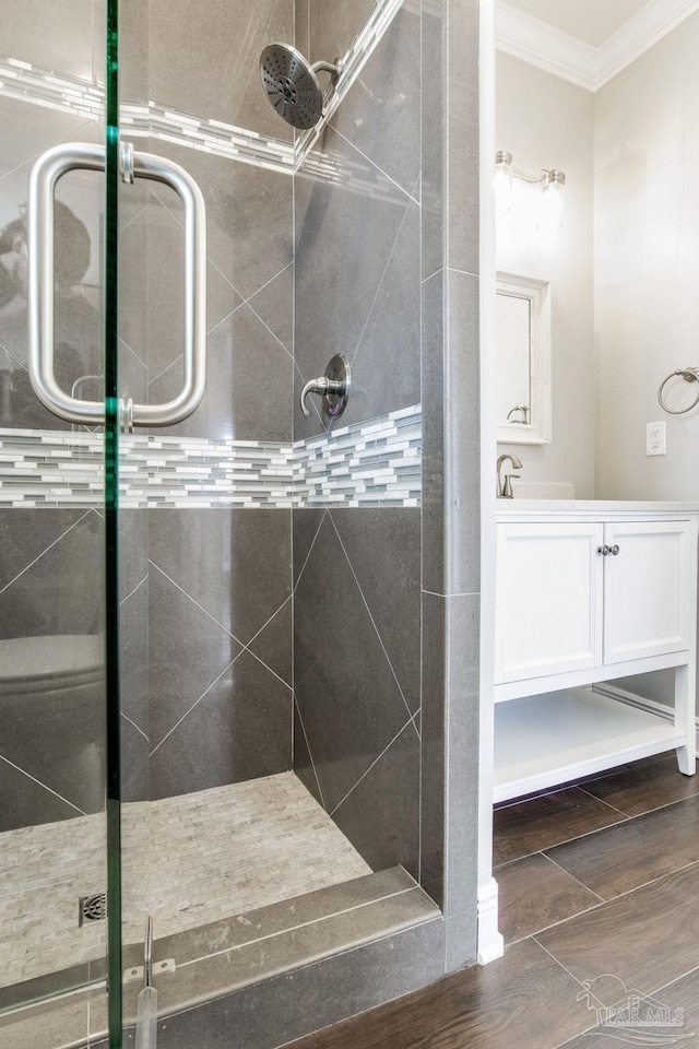 full bathroom with a shower stall, crown molding, and vanity