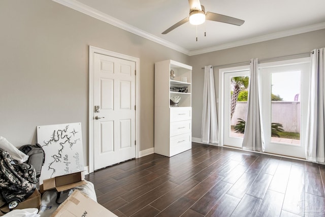 interior space featuring crown molding, baseboards, a ceiling fan, and dark wood finished floors