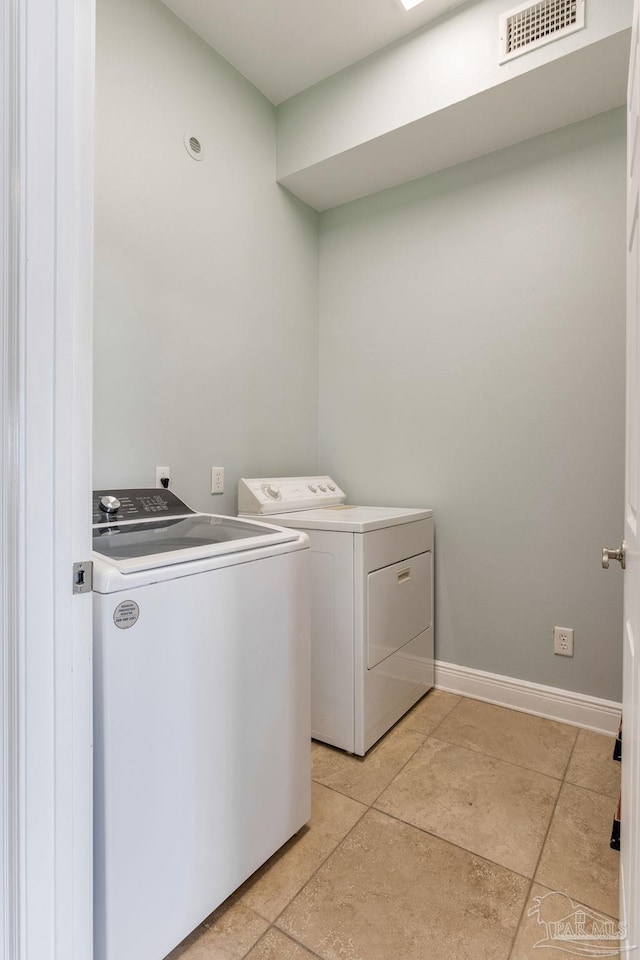 clothes washing area with laundry area, light tile patterned floors, independent washer and dryer, visible vents, and baseboards