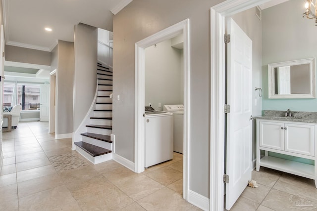 stairway with crown molding, tile patterned floors, and independent washer and dryer