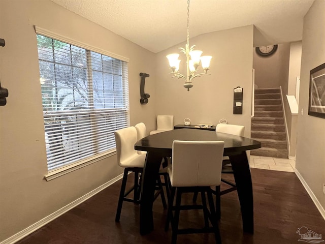 tiled dining space featuring baseboards, lofted ceiling, stairs, and an inviting chandelier