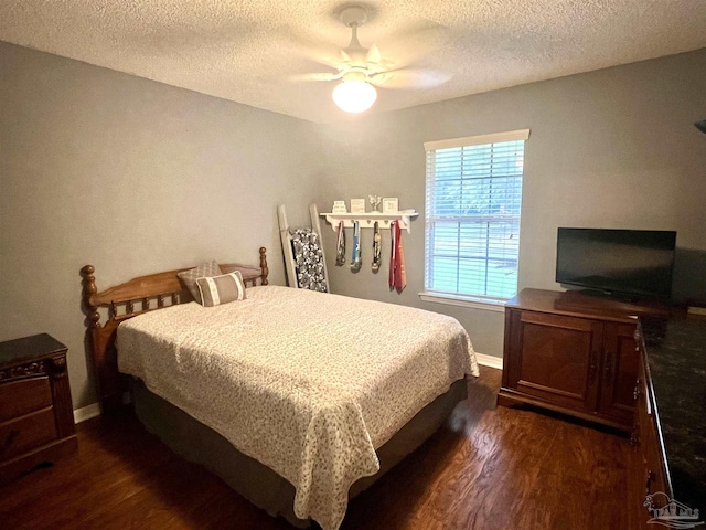 bedroom with a textured ceiling, ceiling fan, and dark wood finished floors