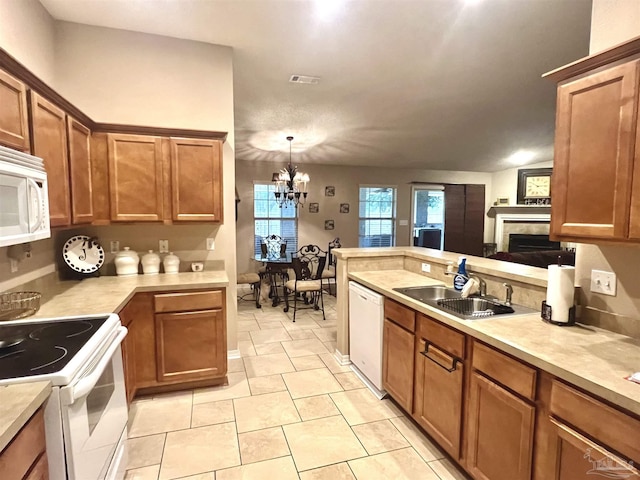 kitchen with light countertops, a sink, brown cabinetry, and white appliances