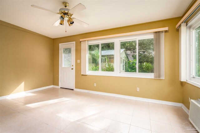 spare room with ceiling fan, plenty of natural light, and light tile patterned floors