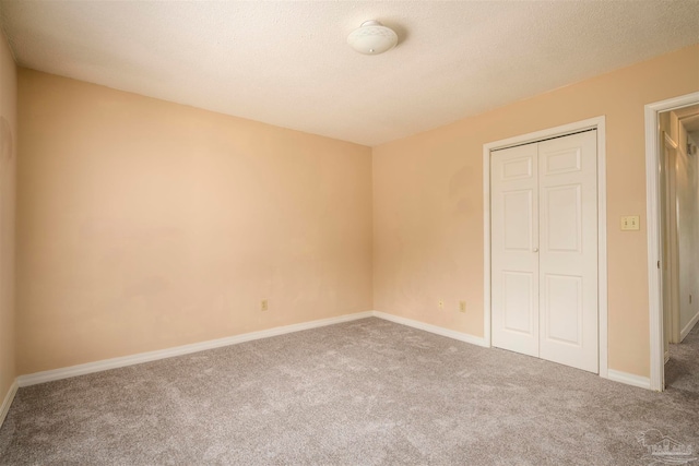 unfurnished bedroom with a closet, carpet flooring, and a textured ceiling