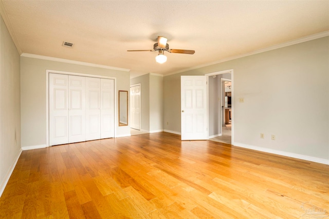 unfurnished bedroom with a textured ceiling, wood-type flooring, crown molding, and ceiling fan