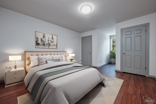 bedroom with dark hardwood / wood-style floors