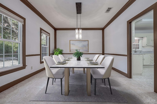 dining room with ornamental molding, a healthy amount of sunlight, and visible vents