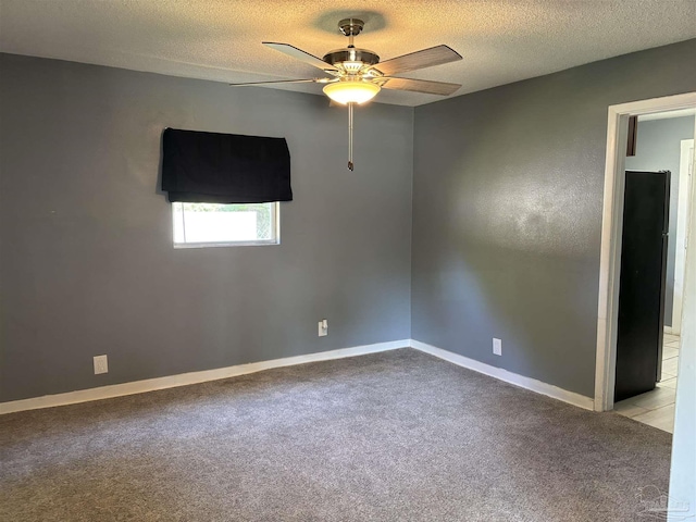 unfurnished room featuring baseboards, carpet flooring, a textured ceiling, and a ceiling fan