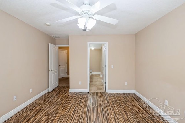 2172 Hadleigh Hills Ct, Navarre, FL 32566 - unfurnished bedroom featuring ensuite bathroom, wood finished floors, and a ceiling fan