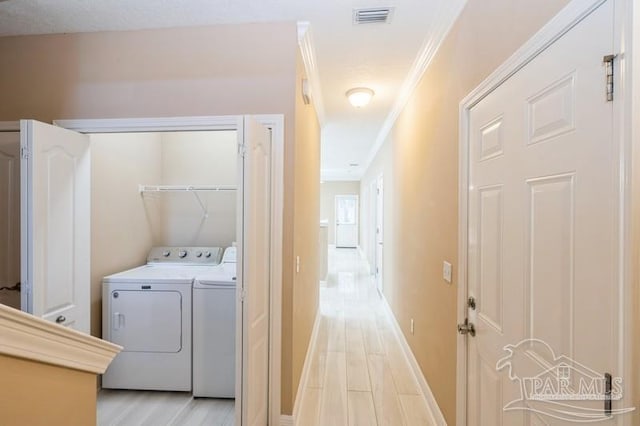 2172 Hadleigh Hills Ct, Navarre, FL 32566 - laundry area with separate washer and dryer, ornamental molding, and light wood-style flooring