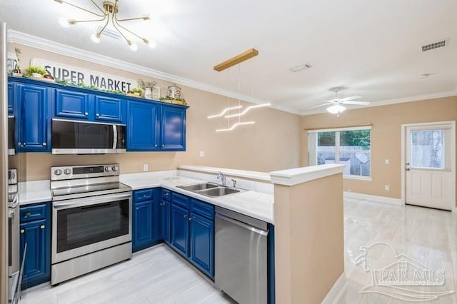 2172 Hadleigh Hills Ct, Navarre, FL 32566 - kitchen with stainless steel appliances, a peninsula, blue cabinets, a chandelier, and ornamental molding