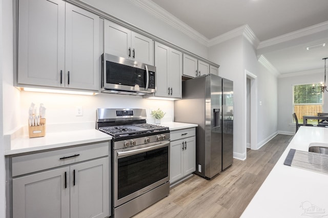 3248 Mountain Laurel Trl, Cantonment, FL 32533 - kitchen with appliances with stainless steel finishes, gray cabinetry, ornamental molding, light countertops, and light wood finished floors
