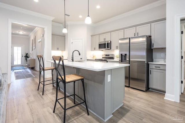 3248 Mountain Laurel Trl, Cantonment, FL 32533 - kitchen featuring stainless steel appliances, gray cabinets, light wood-style flooring, a kitchen breakfast bar, and light countertops