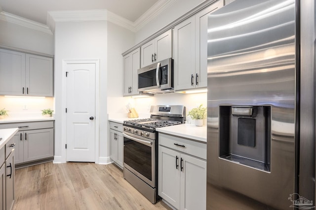 3248 Mountain Laurel Trl, Cantonment, FL 32533 - kitchen with appliances with stainless steel finishes, crown molding, light wood finished floors, light countertops, and gray cabinetry