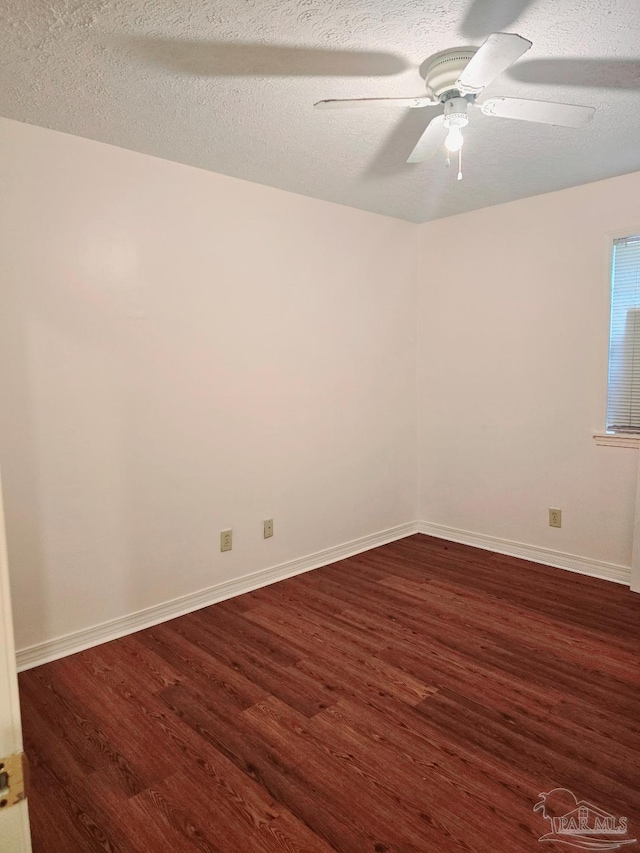 spare room with dark hardwood / wood-style flooring, ceiling fan, and a textured ceiling