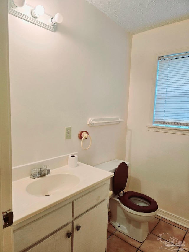 bathroom featuring tile patterned flooring, vanity, toilet, and a textured ceiling