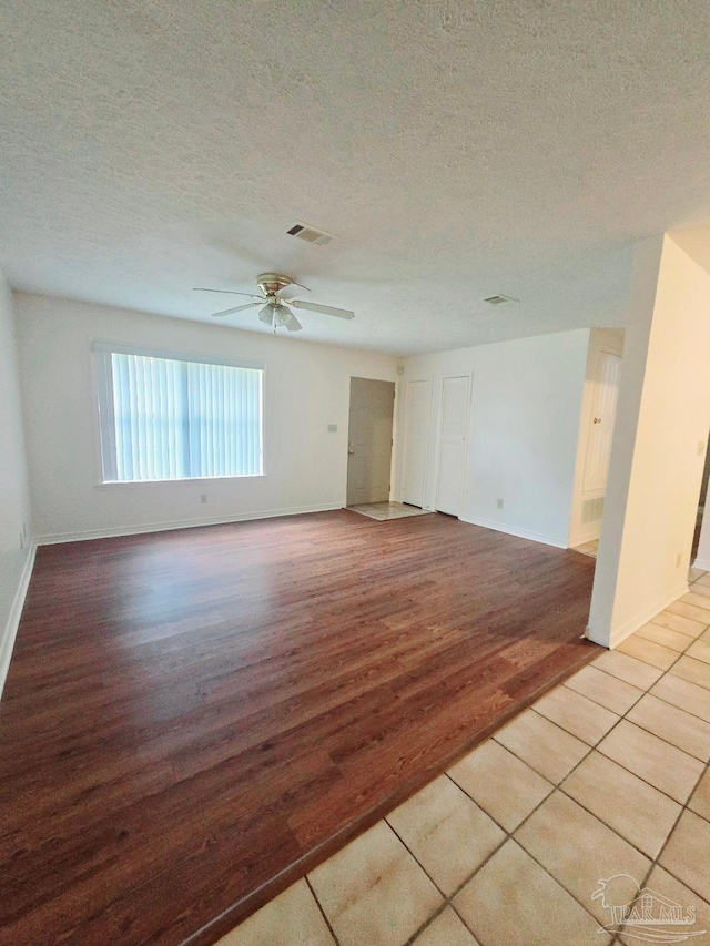 spare room featuring ceiling fan, light hardwood / wood-style floors, and a textured ceiling