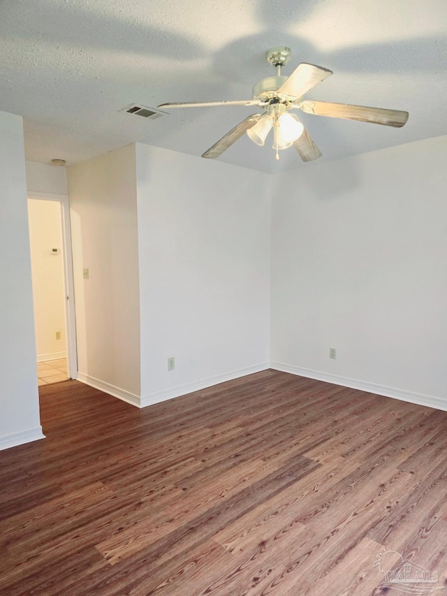 spare room featuring ceiling fan, wood-type flooring, and a textured ceiling