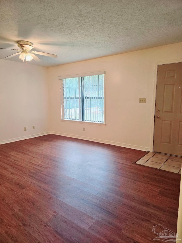 spare room with ceiling fan, a textured ceiling, and dark hardwood / wood-style flooring