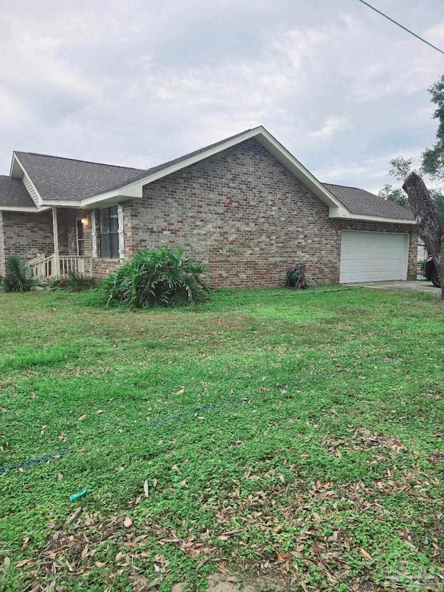 view of side of property featuring a garage and a yard