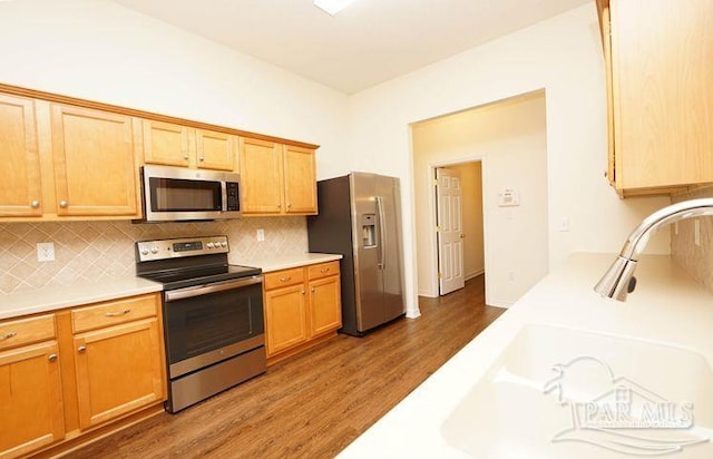8679 High School Blvd, Navarre, FL 32566 - kitchen with stainless steel appliances, a sink, wood finished floors, light countertops, and decorative backsplash