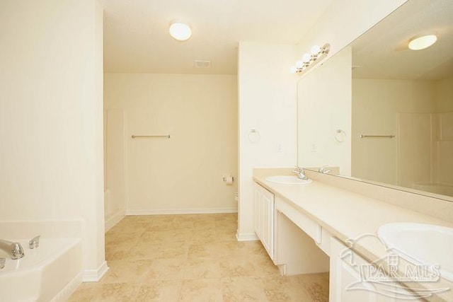 8679 High School Blvd, Navarre, FL 32566 - bathroom featuring a sink, double vanity, a garden tub, and baseboards