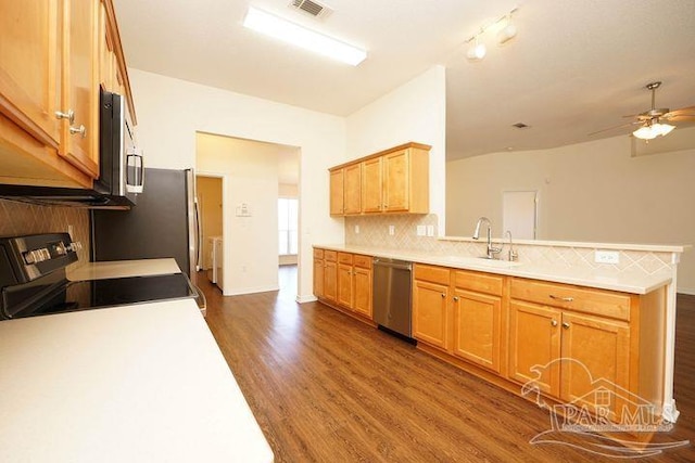 8679 High School Blvd, Navarre, FL 32566 - kitchen featuring a peninsula, dark wood-style flooring, a sink, appliances with stainless steel finishes, and tasteful backsplash