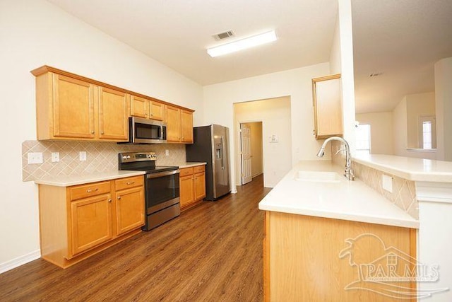 8679 High School Blvd, Navarre, FL 32566 - kitchen featuring visible vents, dark wood finished floors, appliances with stainless steel finishes, a sink, and backsplash