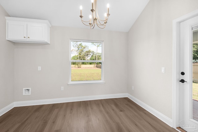 7917 Twin Lake Dr, Milton, FL 32583 - unfurnished dining area featuring wood finished floors, a chandelier, healthy amount of natural light, and vaulted ceiling