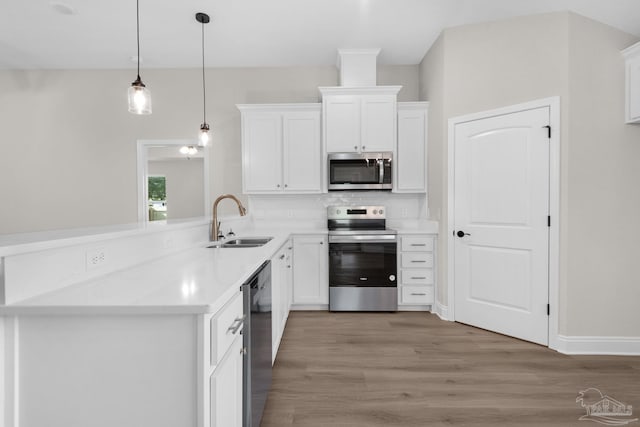 7917 Twin Lake Dr, Milton, FL 32583 - kitchen featuring appliances with stainless steel finishes, backsplash, light wood finished floors, white cabinetry, and light countertops