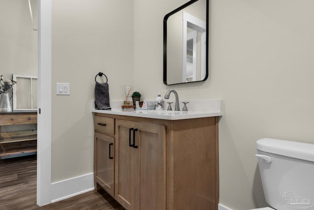 bathroom with vanity, toilet, and wood-type flooring