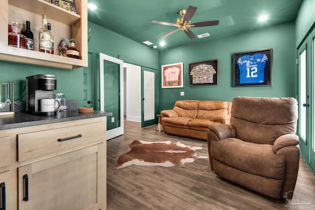 living room featuring ceiling fan and dark hardwood / wood-style flooring