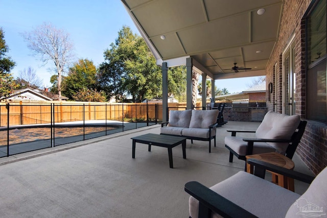 view of patio / terrace with an outdoor living space, exterior kitchen, and ceiling fan