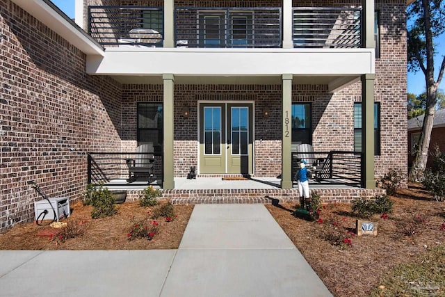 doorway to property featuring a balcony and covered porch