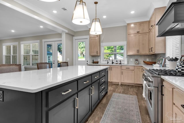 kitchen with high end range, a center island, light brown cabinets, premium range hood, and hanging light fixtures