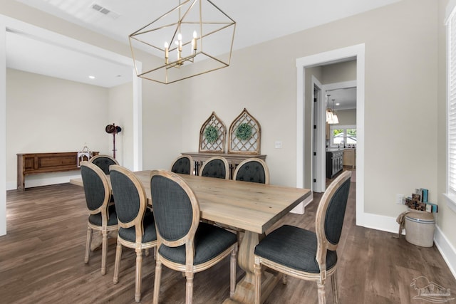 dining area with a chandelier and dark hardwood / wood-style flooring