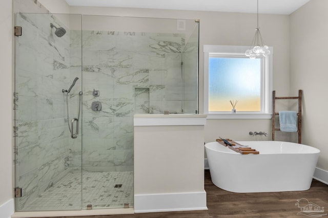 bathroom with hardwood / wood-style flooring and separate shower and tub