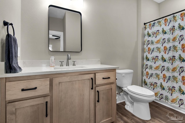 bathroom featuring a shower with curtain, hardwood / wood-style flooring, toilet, and vanity