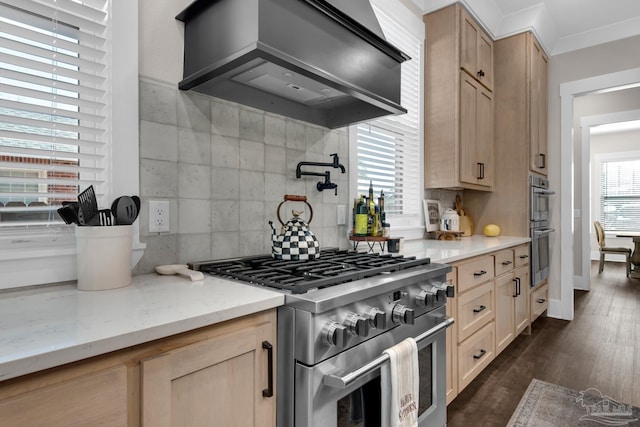 kitchen with premium range hood, stainless steel appliances, light brown cabinetry, and tasteful backsplash