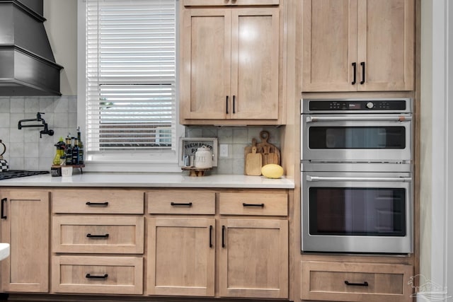 kitchen with light brown cabinets, backsplash, and double oven