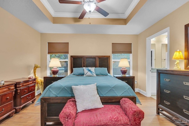 bedroom featuring light wood finished floors, ornamental molding, and a raised ceiling