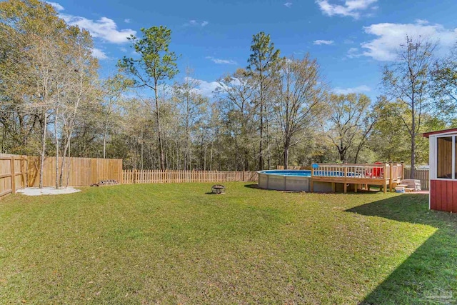 view of yard featuring a fenced backyard, a deck, and a fenced in pool