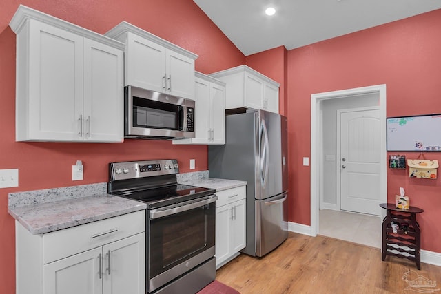 kitchen with light stone countertops, light wood-style flooring, stainless steel appliances, baseboards, and white cabinets