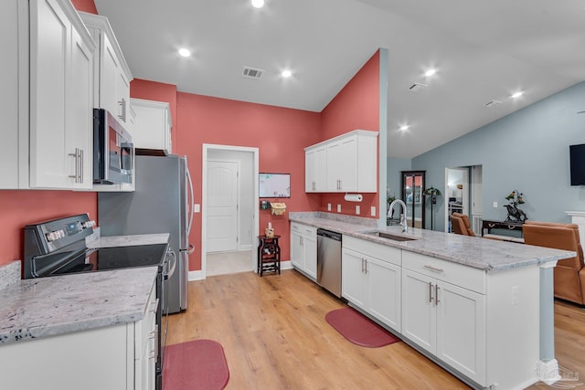 kitchen with a sink, white cabinetry, a peninsula, stainless steel appliances, and visible vents